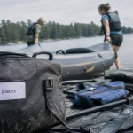 Kayak double dropstitch : deux personnes tirent le kayak gonflable sur la berge